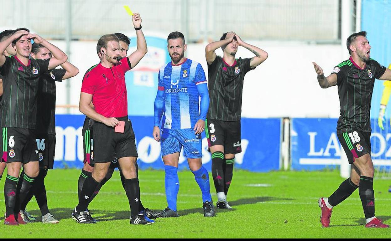 Alcalá Rey amonesta al jugador de la Gimnástica Javi Cobo durante el partido en Avilés. aurelio flórez