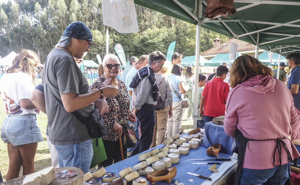 Un hombre compra productos en un stand de quesos. 