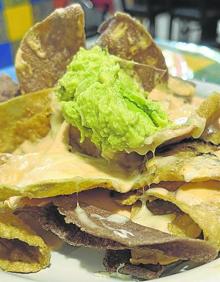 Imagen secundaria 2 - A la izquierda, costilla de cerdo en adobo rojo con patatas, guacamole y tortitas. A la derecha, nachos con queso y guacamole. 