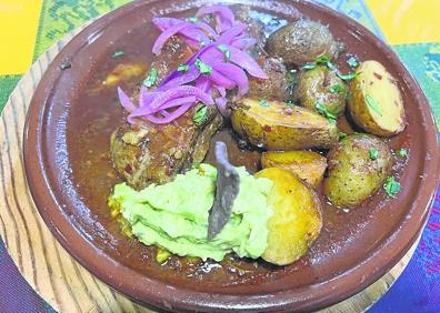 Imagen secundaria 1 - A la izquierda, costilla de cerdo en adobo rojo con patatas, guacamole y tortitas. A la derecha, nachos con queso y guacamole. 