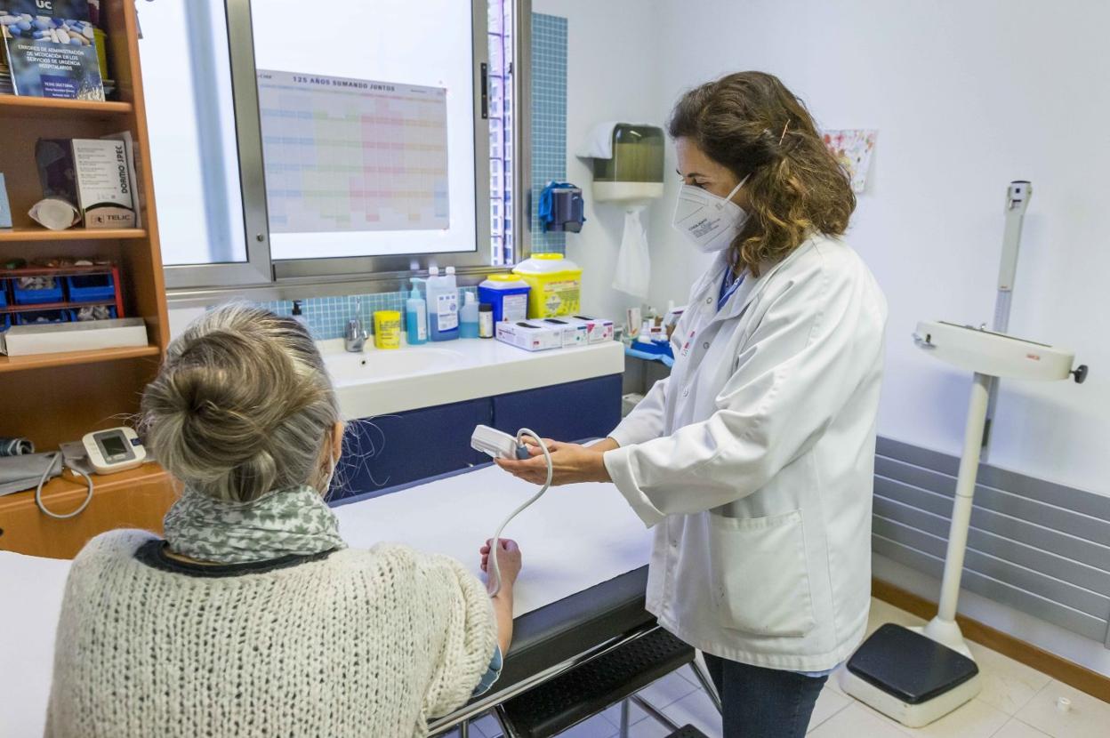 Consulta en un centro de salud, donde se está tomando la tensión a una paciente. 