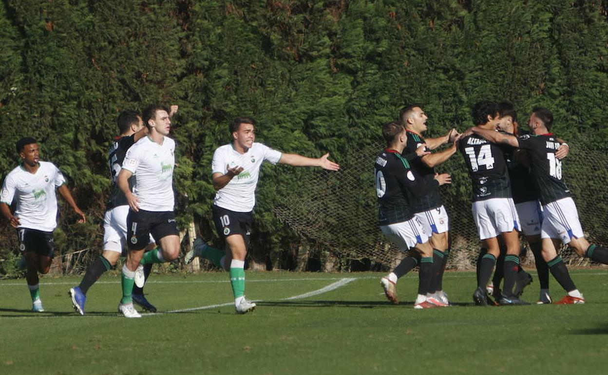 Los jugadores de la Gimnástica celebran el gol del triunfo ante las protestas de los futbolistas del Rayo Cantabria.