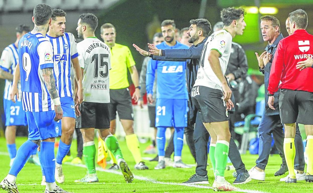 Los jugadores del Racing y del Alavés discuten a la espera de que el árbitro delibere tras consultar al VAR. 