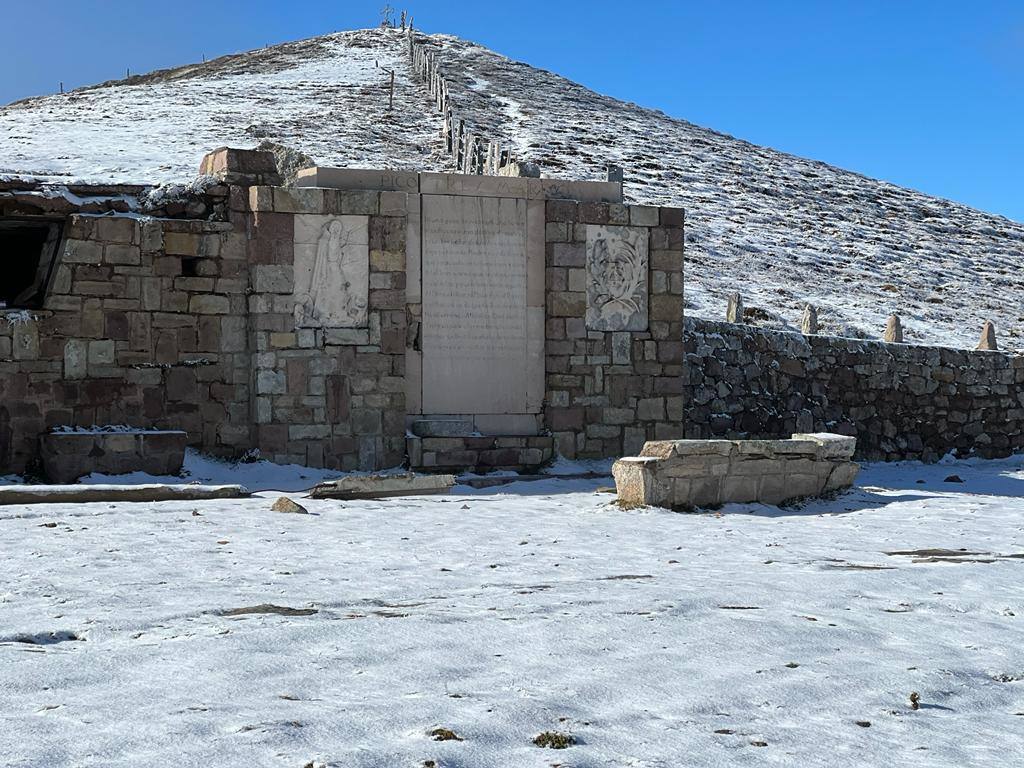 Pequeño refugio de piedra con un poema de Gerardo Diego dedicado al pico Tres Mares, en la explanada de la Fuente de El Chivo.