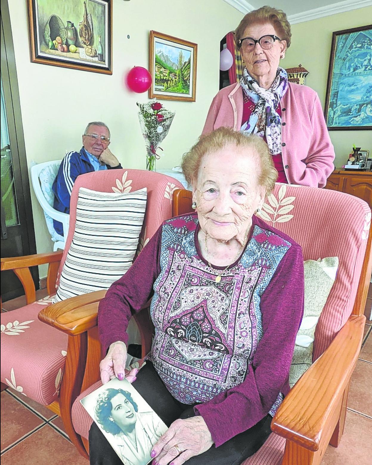 Martina, con una foto suya de joven, su hermana y su cuñado. 