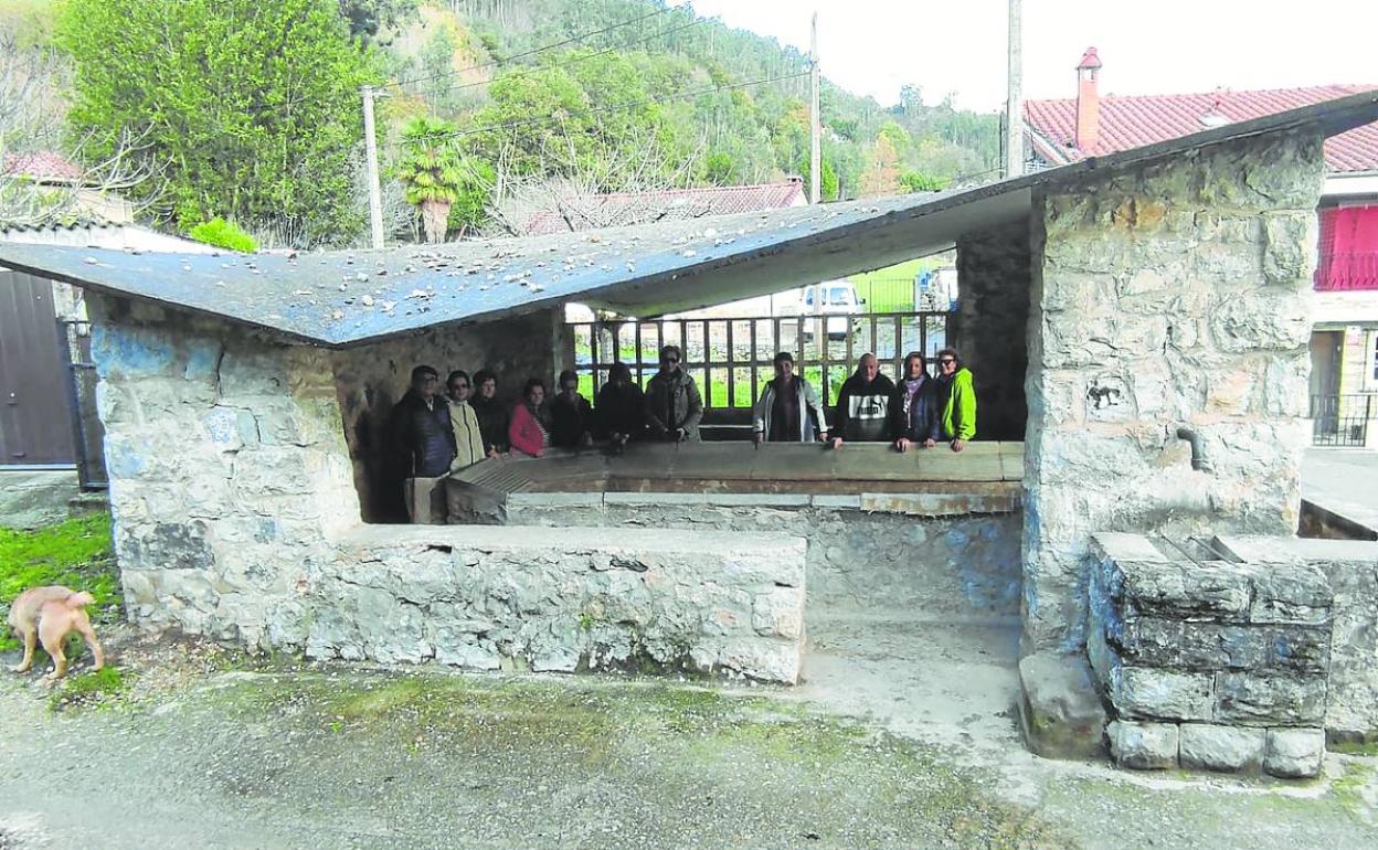 El viejo y sorprendente lavadero de Santián, en Barros, con los paseantes bajo su especial cubierta.