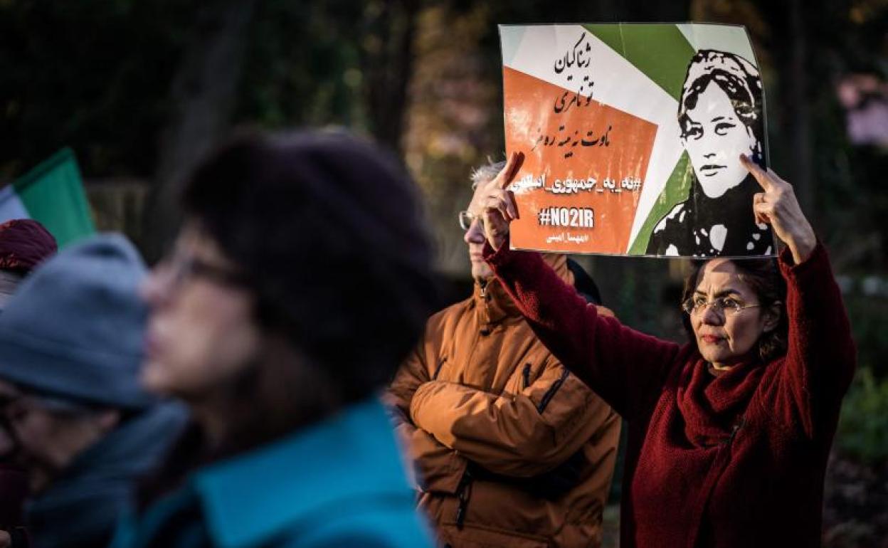 Una mujer sostiene un cartel en apoyo a Mahsa Amini durante una manifestación frente a la Cámara de Representantes en La Haya. 