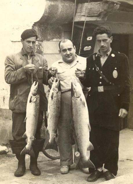 Imagen - Celedonio Pérez Abascal 'Lonio el molinero'; Elisardo Moya 'Sardo', dueño del bar la Tropical, y Lesmes Arroyo, guardarríos, posando con tres ejemplares de salmón frente a La Tropical de Puente Viesgo en 1962. Foto: Pedro de la Vega.