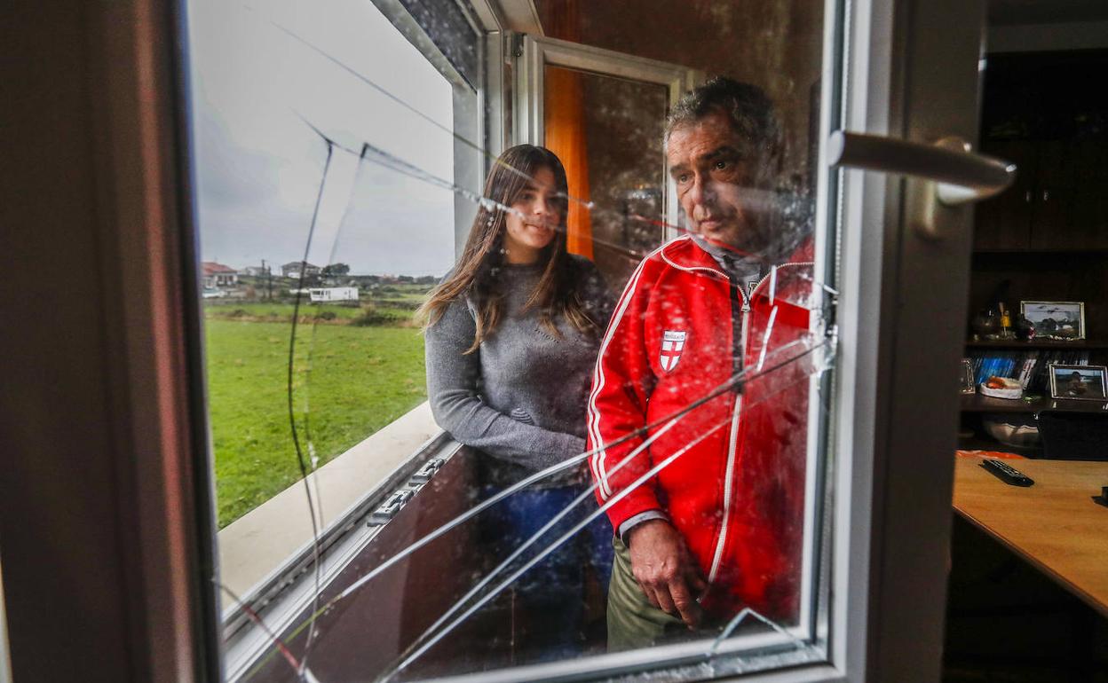 Emilio Diego y su hija Ana, tras la ventana por la que los asaltantes entraron a robar a su vivienda.