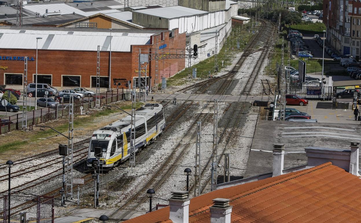 Un tren atraviesa la intersección de Pablo Garnica tras abandonar la estación de FEVE de Torrelavega. 