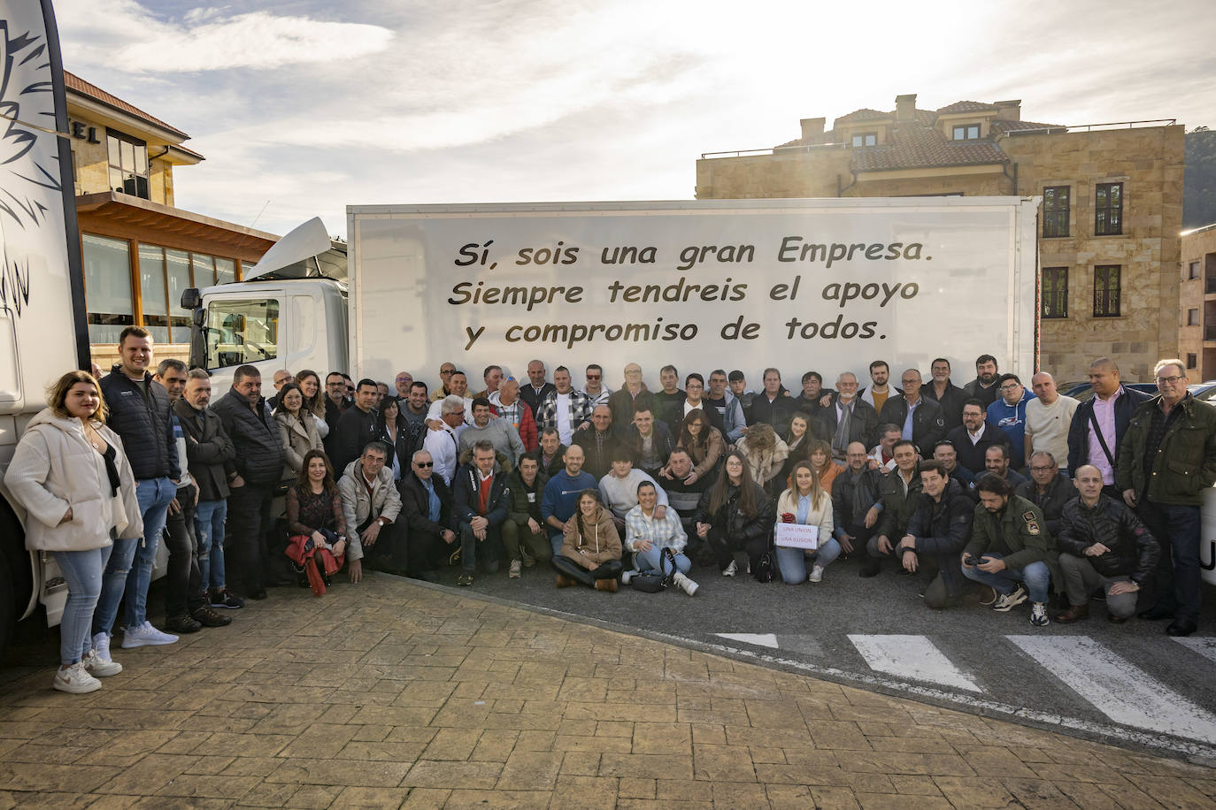 Foto de familia de los cuatro propietarios de la empresa Transportes Victoriano Saiz Echevarría e Hijos junto a sus trabajadores 