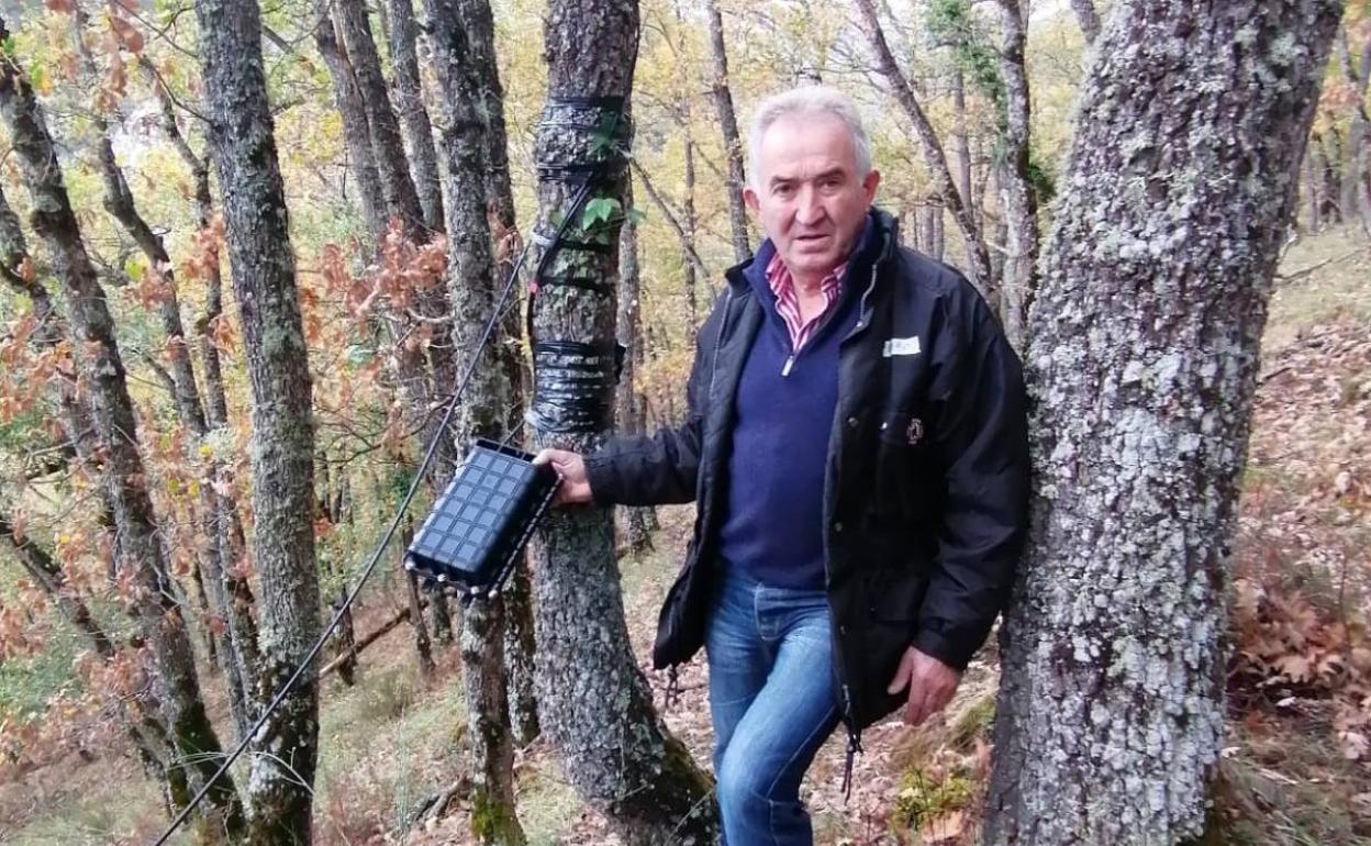 Pedro Vejo muestra uno de los puntos en los que el cable está amarrado a los árboles. 