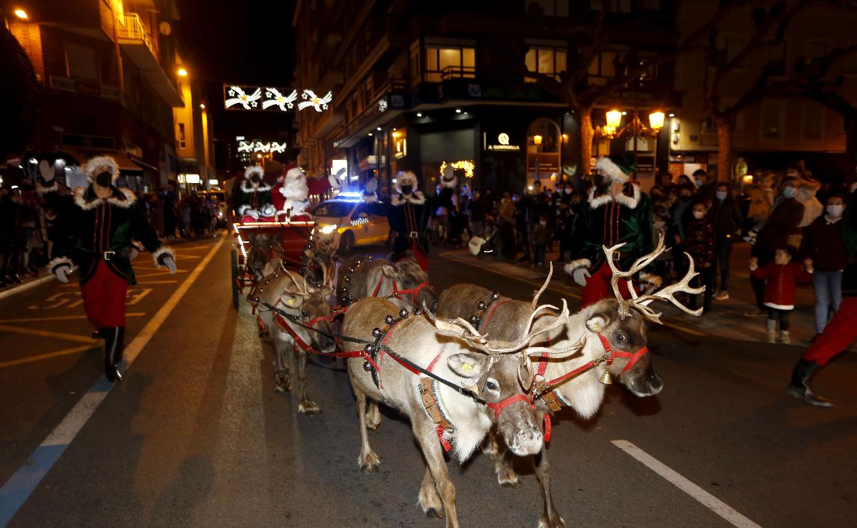 Cuatro renos tiran del carruaje de Papá Noel por las calles de Torrelavega en 2021.