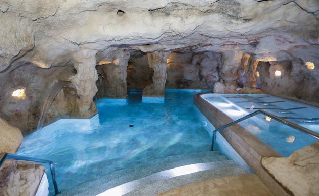 La gran piscina. A la derecha, una serie de camas en cuyo techo hay manos pintadas en tonos rojos, como en la cueva del Castillo. 