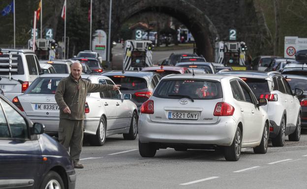 Un trabajador organiza y dirige a los vehículos a la entrada del Parque.