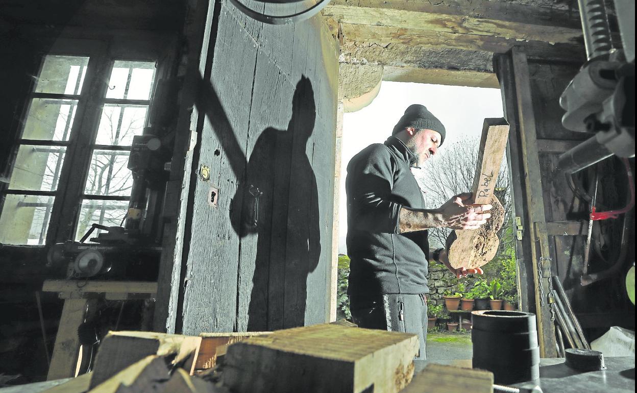 David López García observa el trozo de madera que utilizará para hacer el rabel de la colección. 