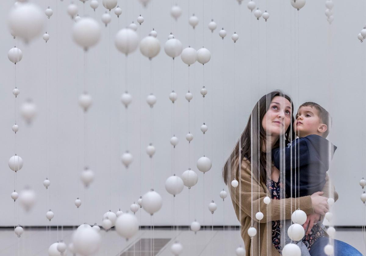 El pequeño Carlos, de dos años y su madre, Marina, observan la obra 'Warp Cloud'.