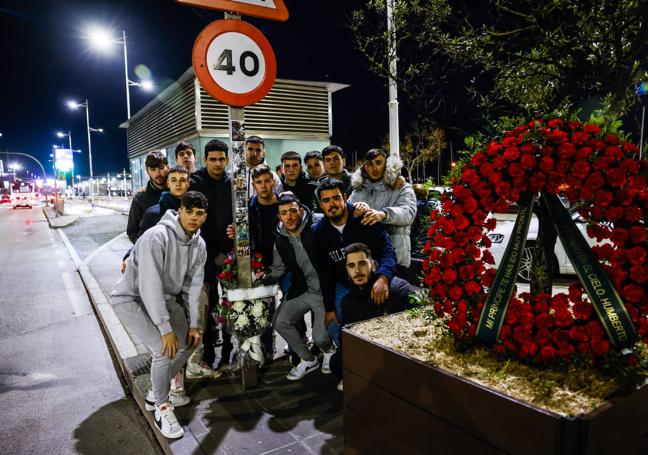 Un grupo de amigos de Bret Elorza, ayer por la tarde, en el paseo, donde colocaron una corona de flores y pegaron fotografías con el joven.