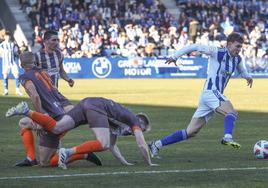 Basurto, de la Gimnástica, conduce el balón y se va de varios jugadores del Avilés.