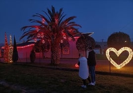 Una pareja detiene el paso para hacerse una foto delante de la casa de Parbayón que ahora también ilumina San Valentín