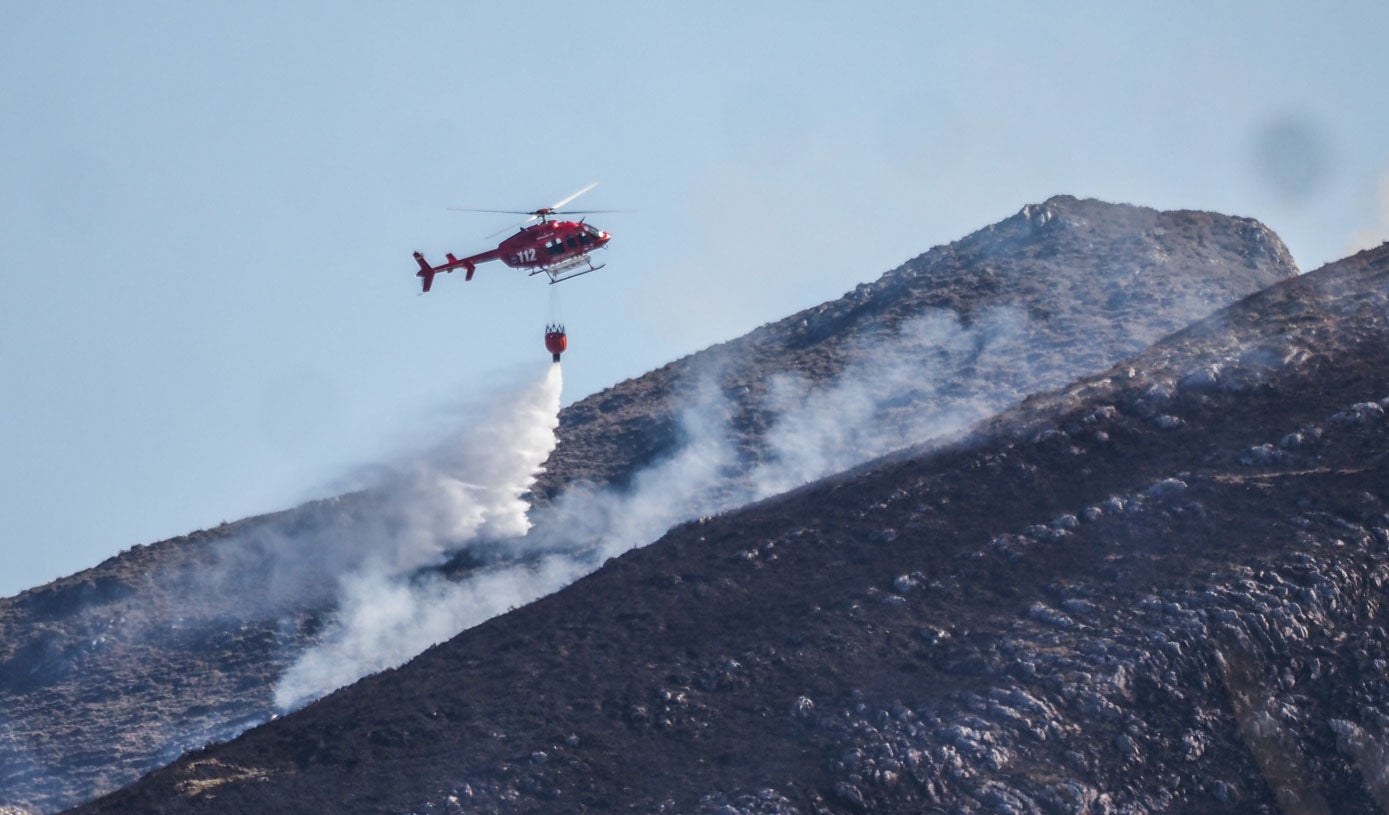 El helicóptero del 112 apaga uno de los focos originados en Linto (Miera) después de coger agua en los pozos de Noja.