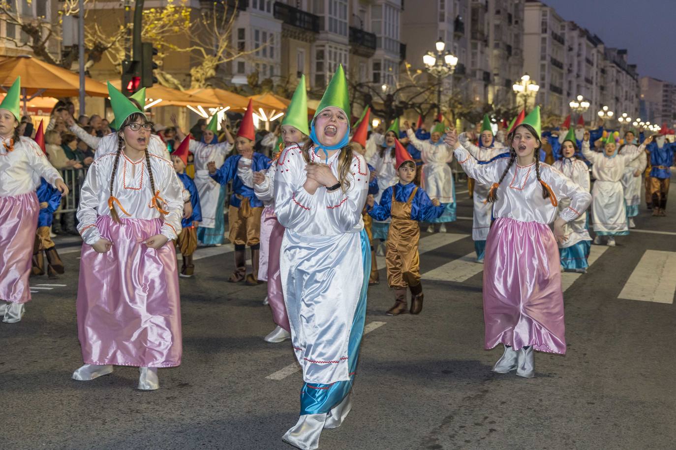 Varios miembros de una de las comparsas participantes cantan y bailan durante su actuación en el desfile.