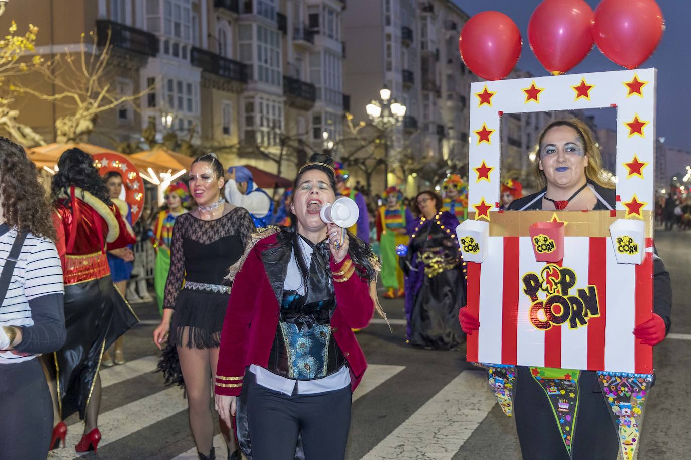 Una participante del pasacalles, disfrazada de domadora, canta con un megáfono.