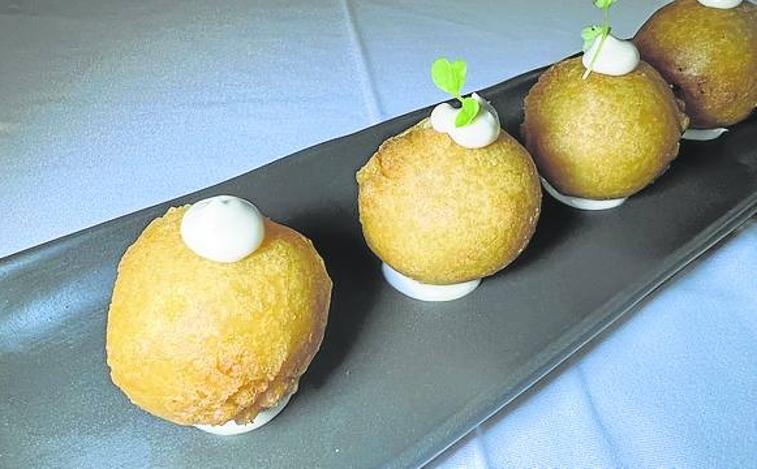 Imagen principal - Algunos platos de la cocina de La Antigua: buñuelos cremosos de bacalao, alcachofas confitadas y salteadas y tarta de queso