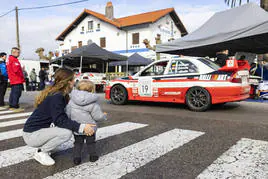 Un joven aficionado contempla el coche de los ganadores, Ricardo y Moisés Gómez