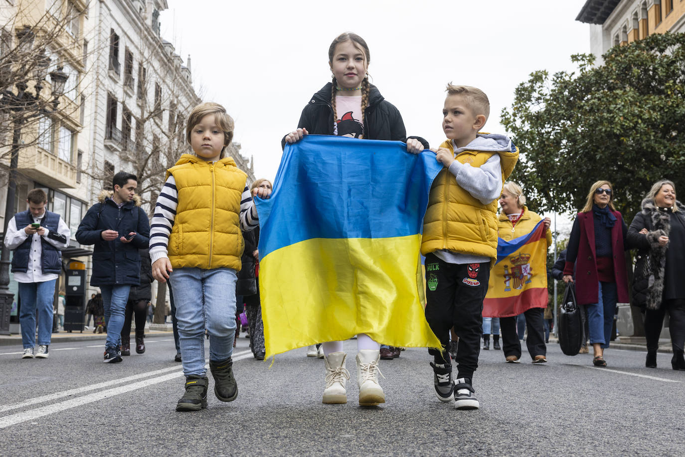 Tres pequeños portan la bandera de Ucrania