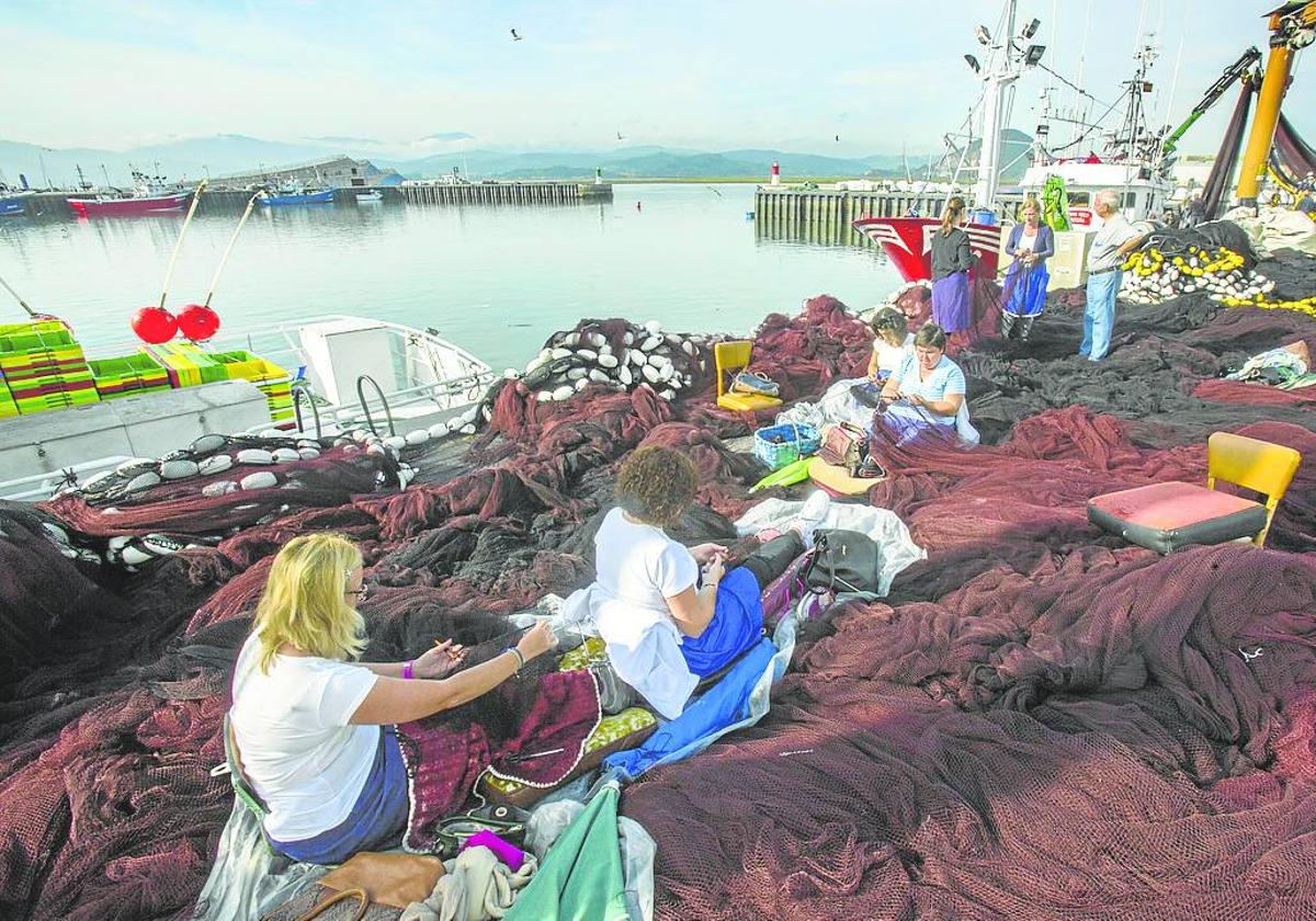 Mujeres cosiendo las redes de pesca, rederas, en el Puerto de Santoña.