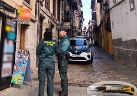 Agentes de la Guardia Civil delante de la puerta del establecimiento situado en la calle Ruamayor de la Puebla Vieja de Laredo.