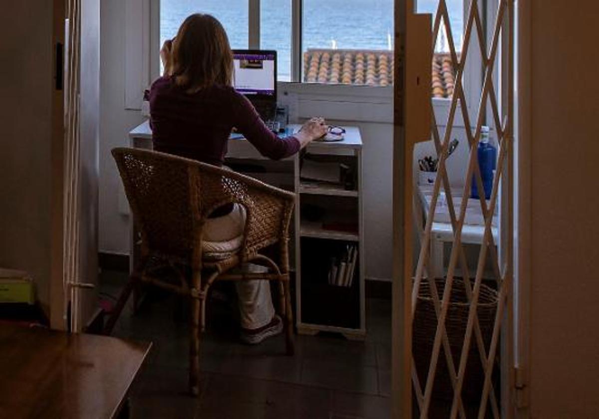 Foto de archivo de una mujer teletrabajando en su casa.