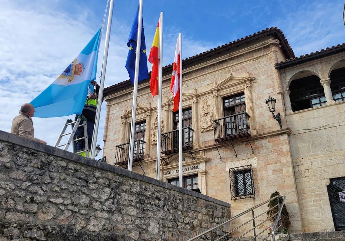 Un operario durante la colocación, este viernes, de las banderas en el exterior del Ayuntamiento barquereño.