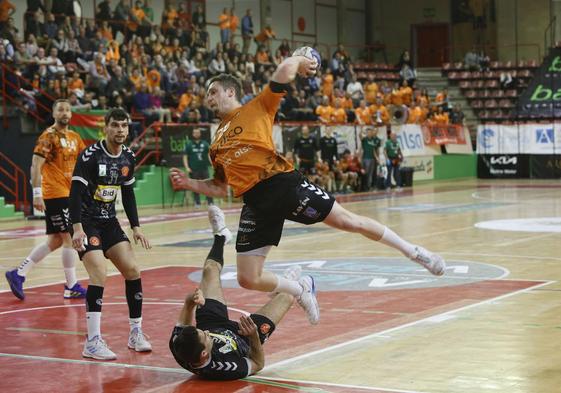 Oswaldo Maestro, del Bathco, se dispone a lanzar a portería ante dos rivales del Bada Huesca