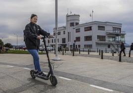 Una usuaria de patinete eléctrico circula por el carril bici ubicado junto al Club Marítimo de Santander.