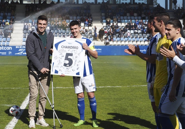 El capitán de la Gimnástica, Alberto Gómez, hace entrega de una camiseta firmada por la plantilla a Chamorro.