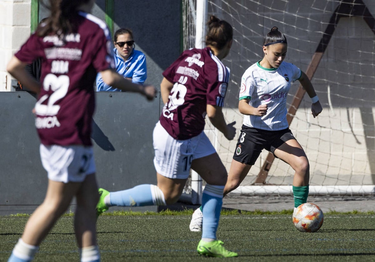 Naara Miranda conduce el balón mientras dos rivales del Interrías tratan de frenarla