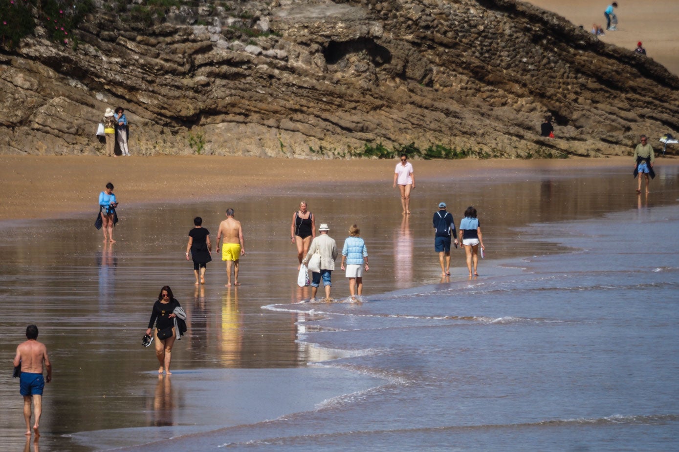 Pantalones remangados, zapatos en mano y bañadores han sido los protagonistas en Santander este martes con la primavera recién estrenada.