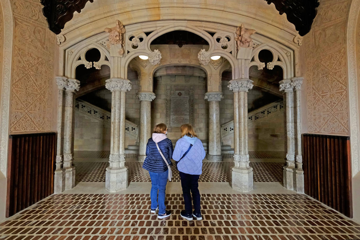 Dos mujeres se fijan en el detalle de la restauración de algunos elementos