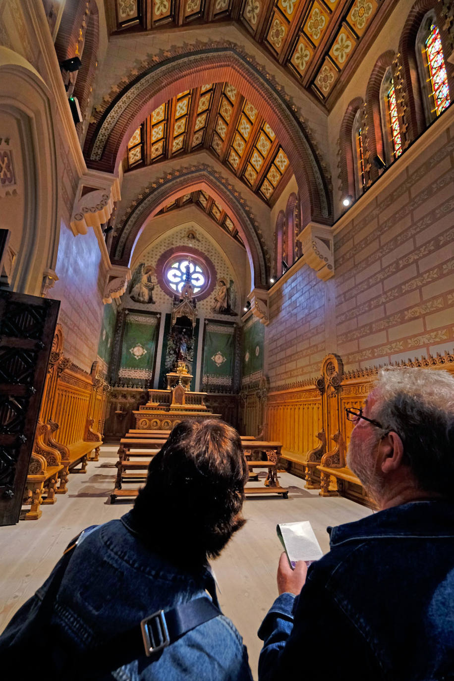 Dos personas observan el altar de la Iglesia del Seminario Mayor