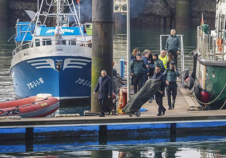 Agentes y personal del juzgado proceden al levantamiento de los cadáveres de los dos marineros fallecidos, trasladados al Puerto por el Siempre Nécora y el Ave Fénix.