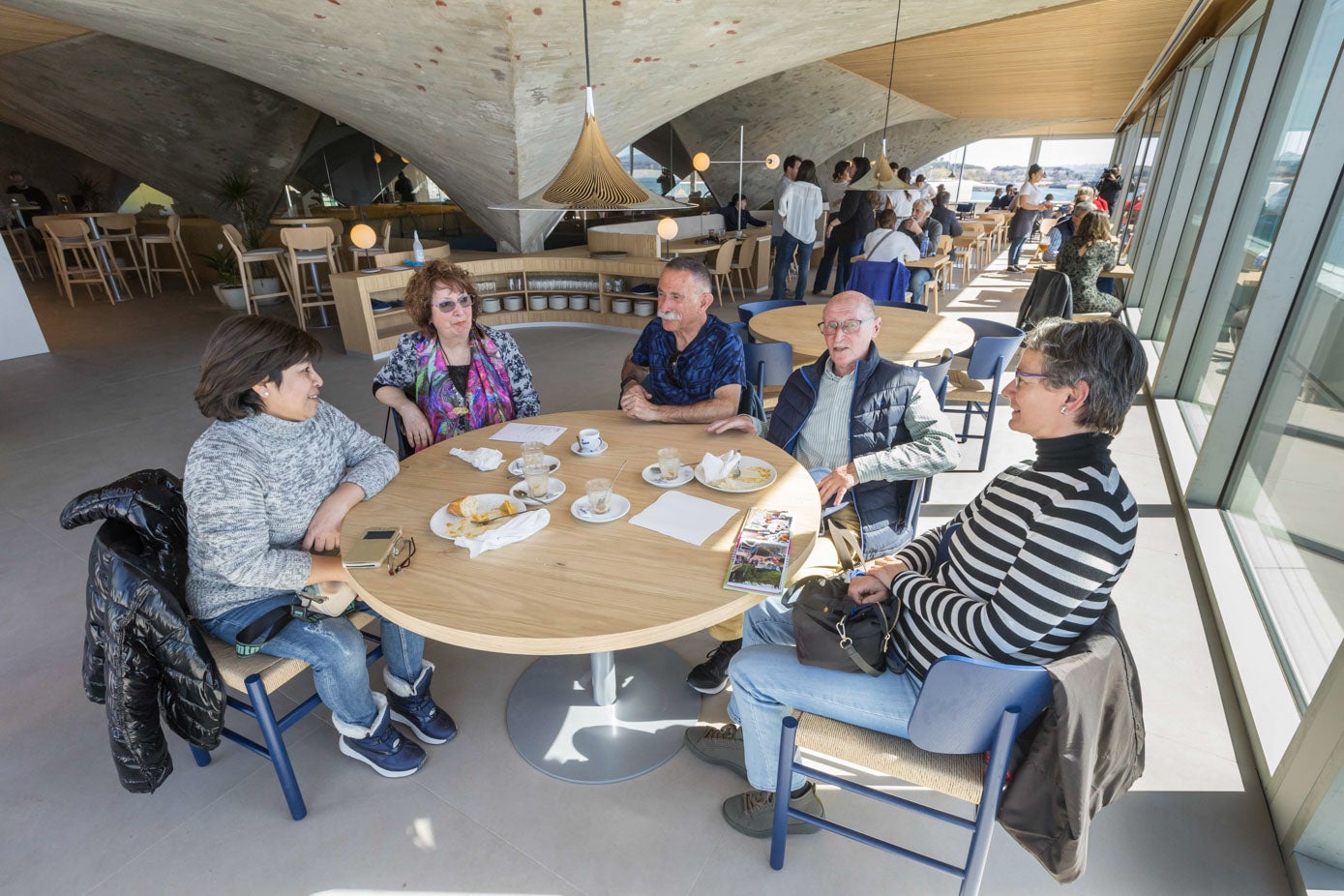 Un grupo de amigos, este miércoles, disfruta del desayuno con vistas a la bahía en el primer día de apertura de la cafetería