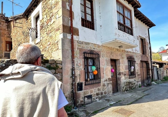 Un vecino pasa junto a la vivienda que había sido okupada ahora decorada con globos.