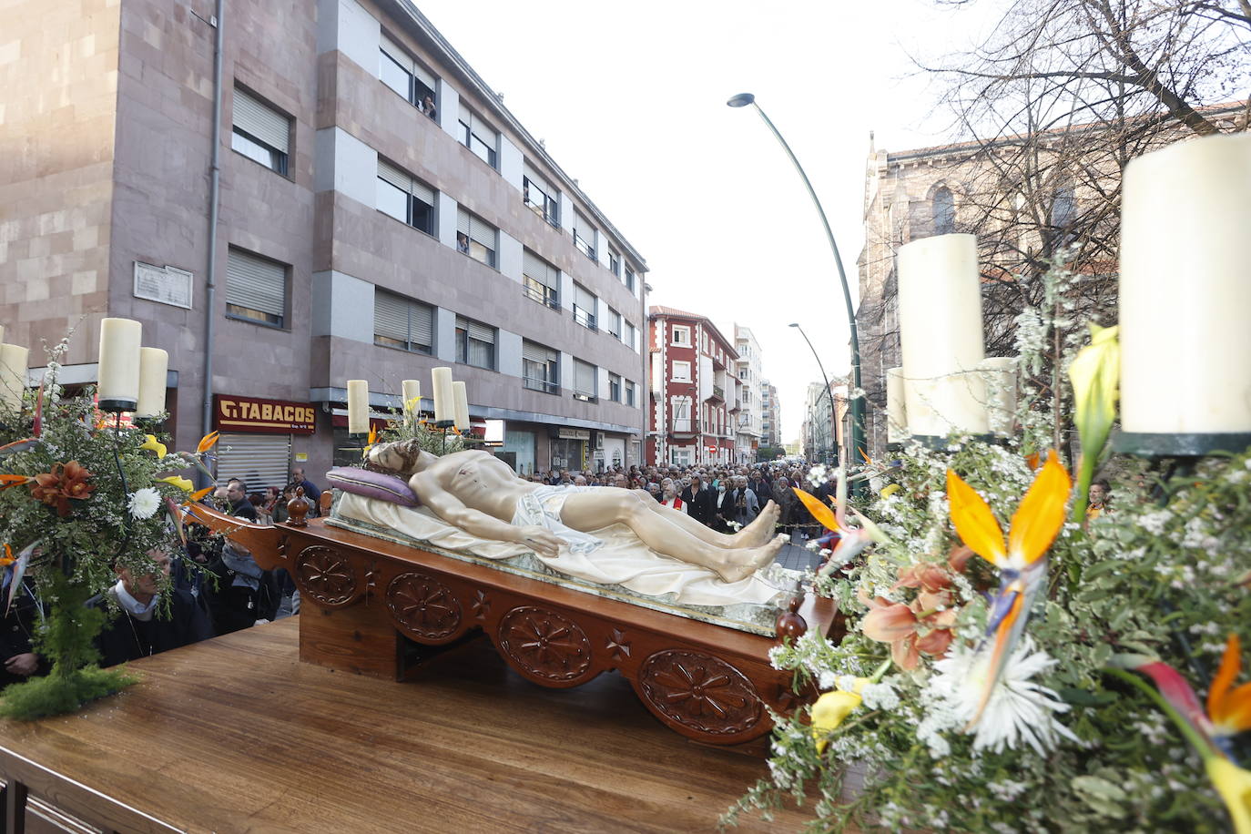 Paso del Cristo Yacente con multitud de fieles en segundo plano.