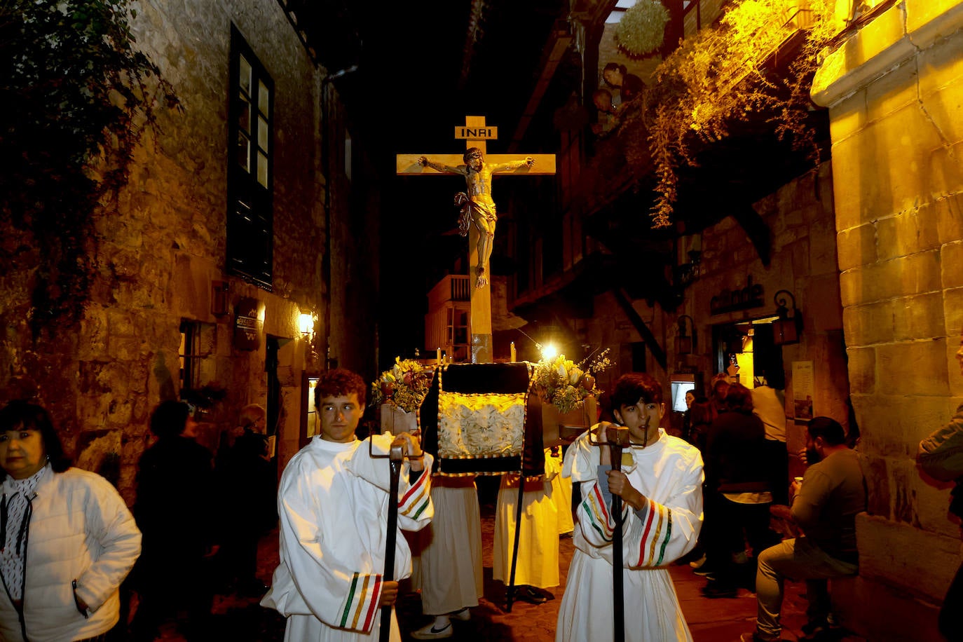 Uno de los pasos del Vía Crucis de Santillana, con dos cofrades portando la escultura del cristo.