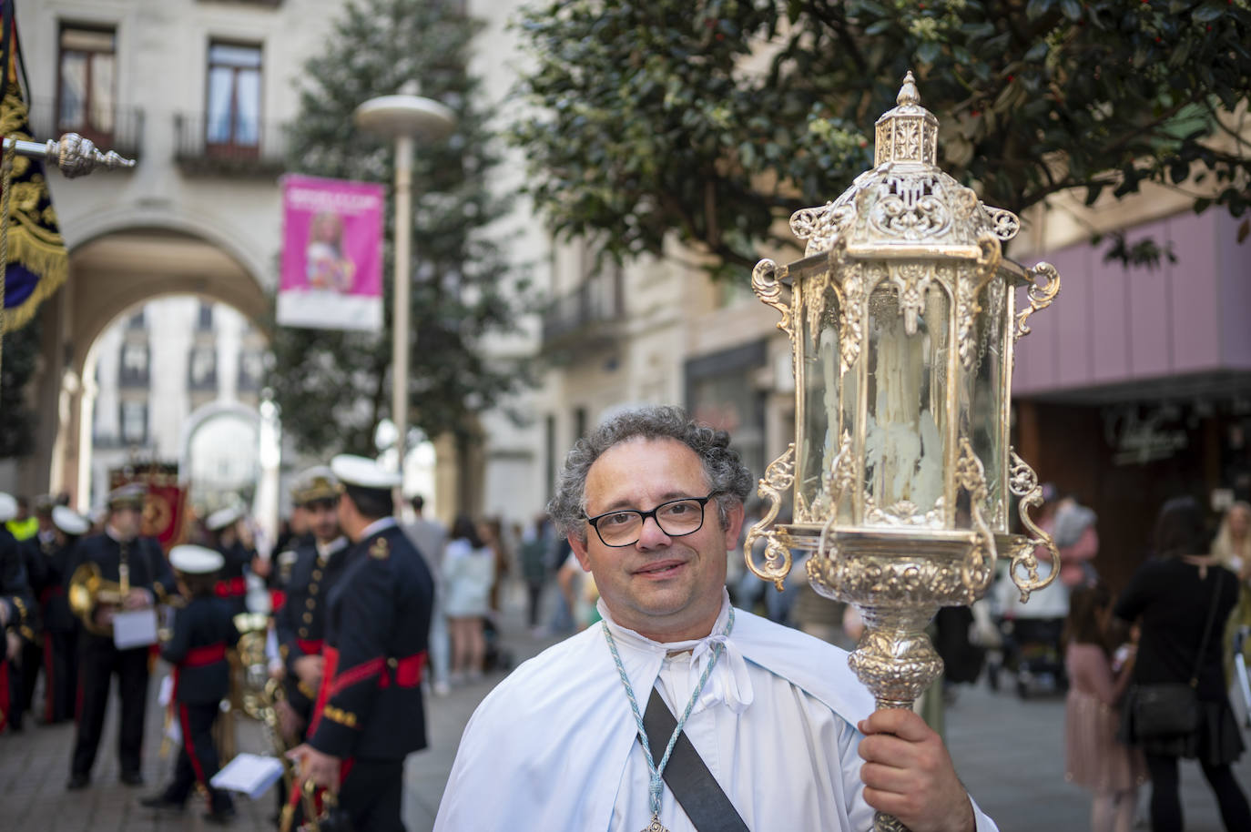 Un cofrade con un farol procesional junto a la plaza Porticada.