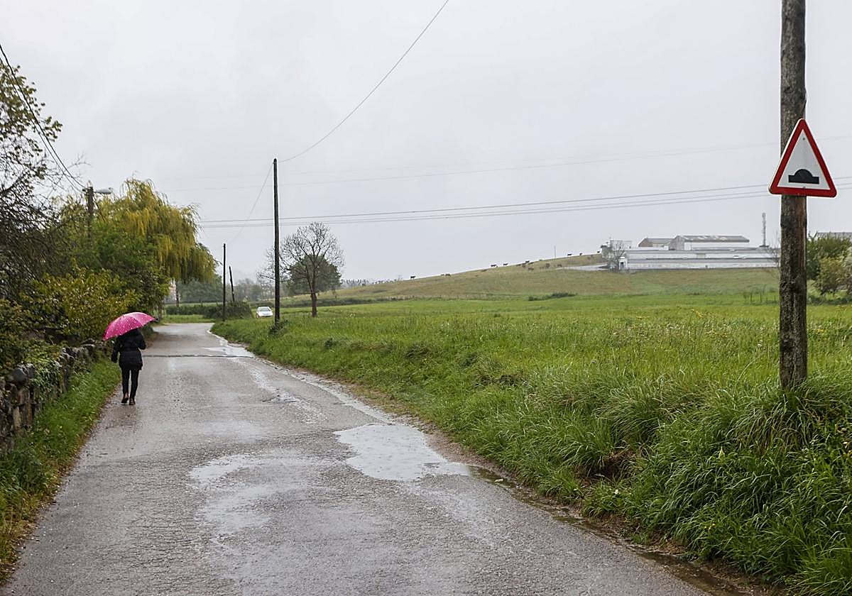 Una mujer camina a un costado de los terrenos de Las Excavadas, ayer, en el suroeste de Torrelavega.