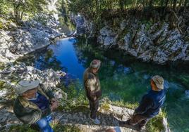 Miguel Ortiz, Ignacio Martínez y Roberto López observan el bajo nivel del río Pas en el coto de Covanchón de la localidad de Puente Viesgo.