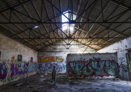 Una joven observa el interior de uno de los antiguos inmuebles militares abandonados que se encuentran en lo alto de la finca de La Remonta, en Santander.